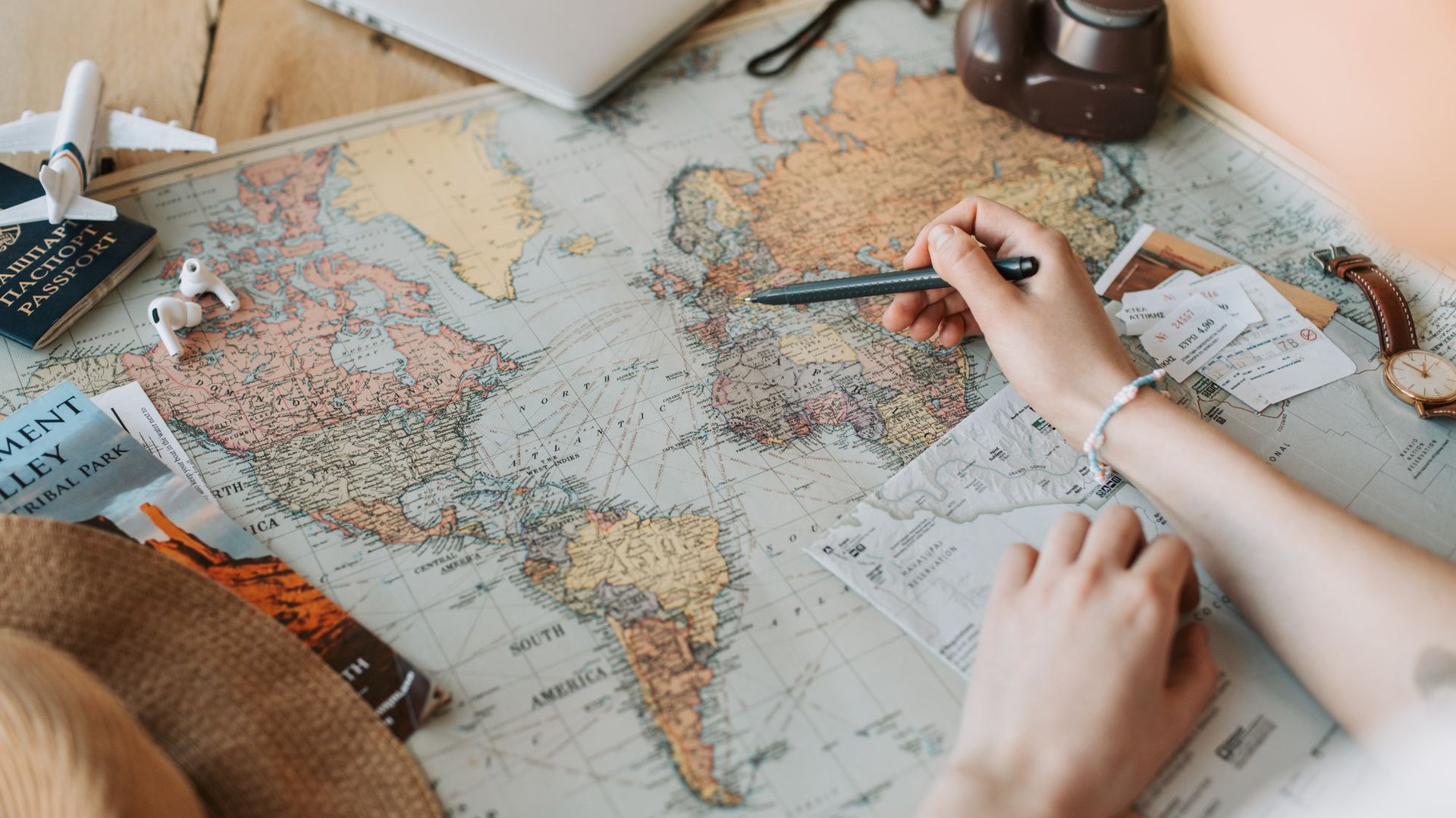 Travel planning flat lay with a world map, passport and camera